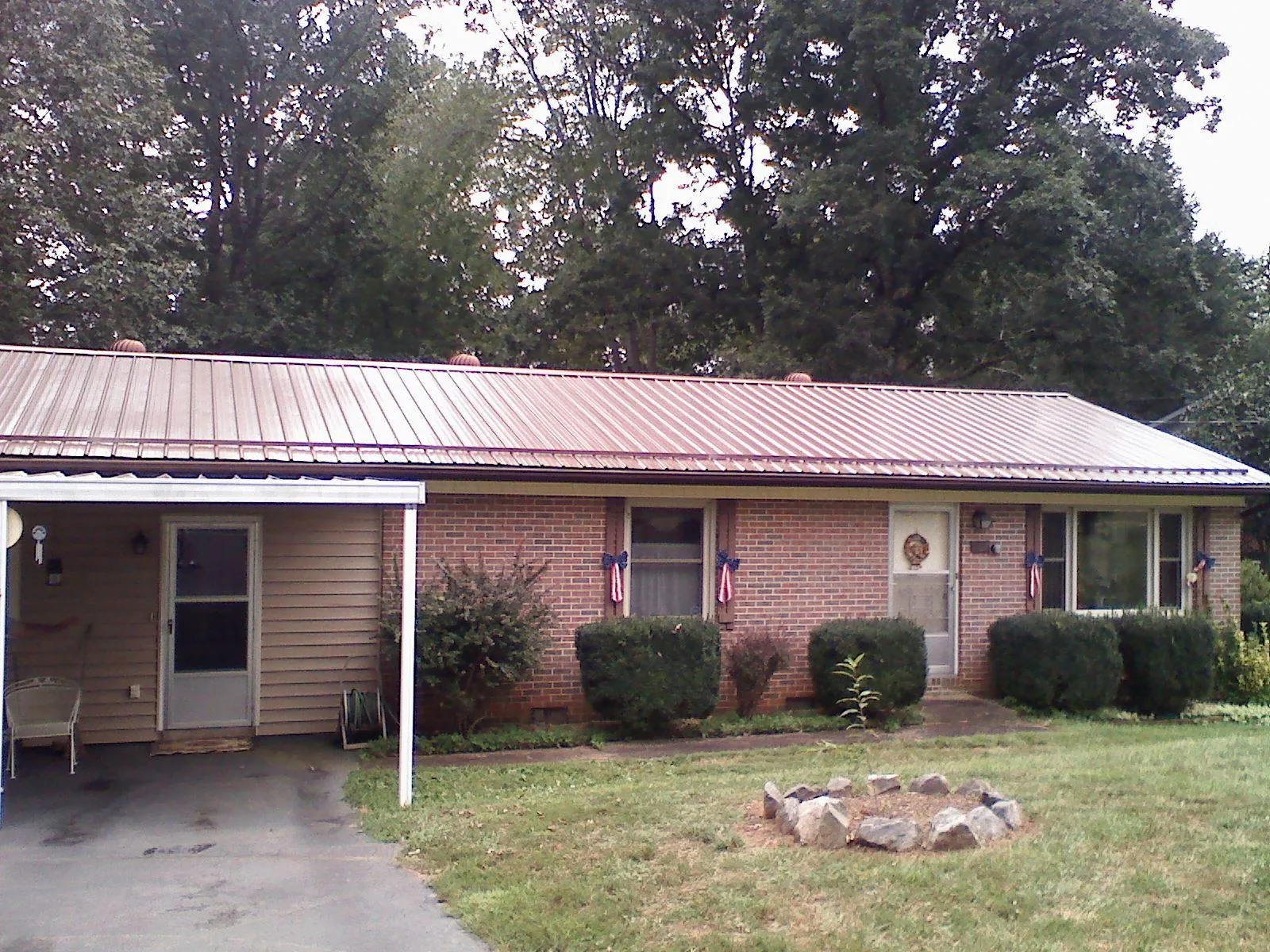 Bronze metal roof and carport on a brick ranch home — Roof Repair work by our crew in Columbia